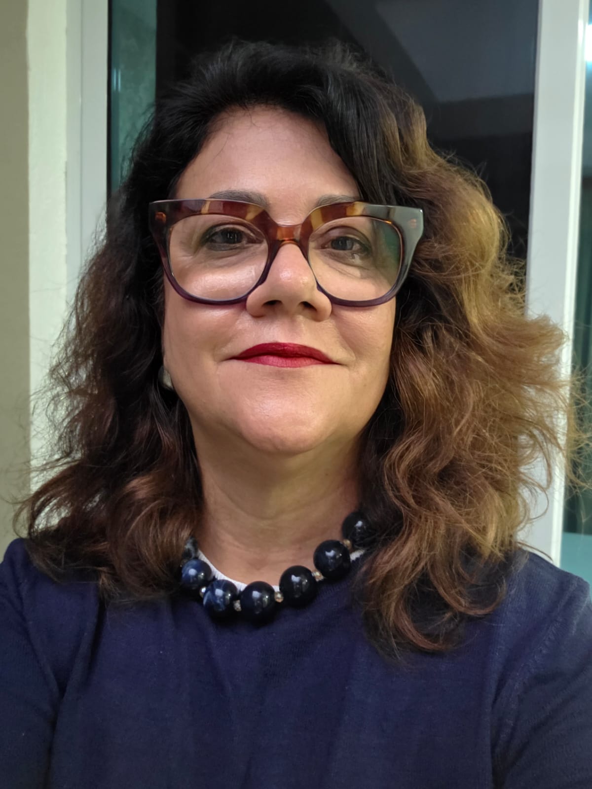 Ana Cristina sorrindo, de blusa azul-marinho